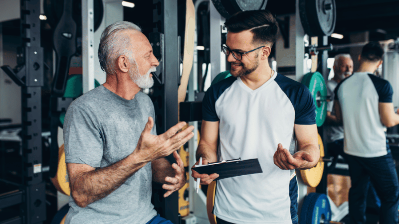 Fitserve coach consulting with a senior client in the gym